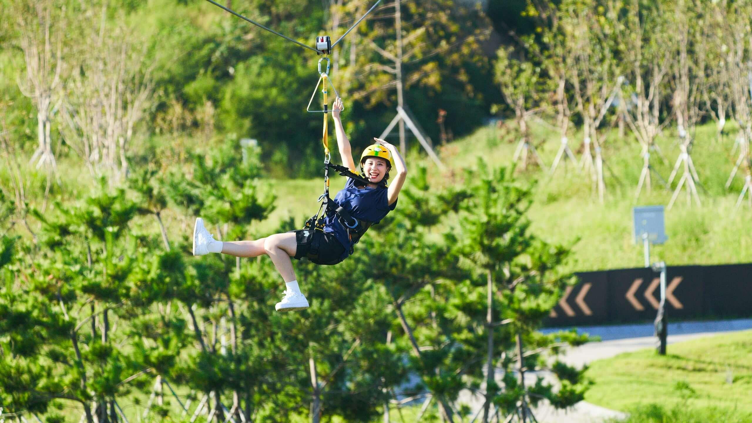 A lady smiles as she nears the end of the Hyfly zipline.