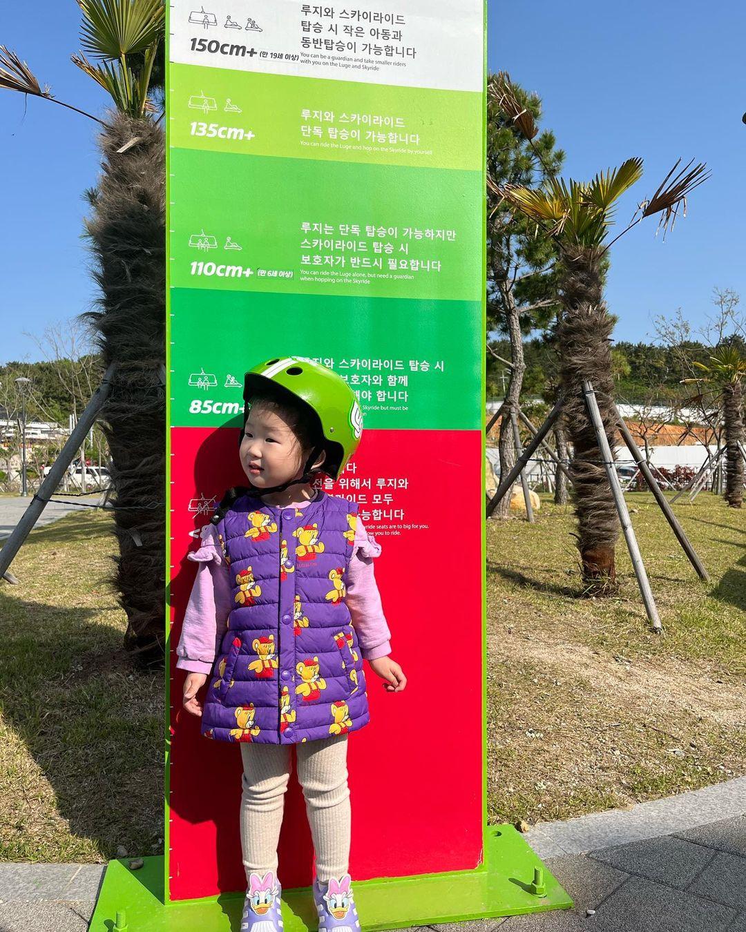 A small child checks her height to ride the Luge at Busan.