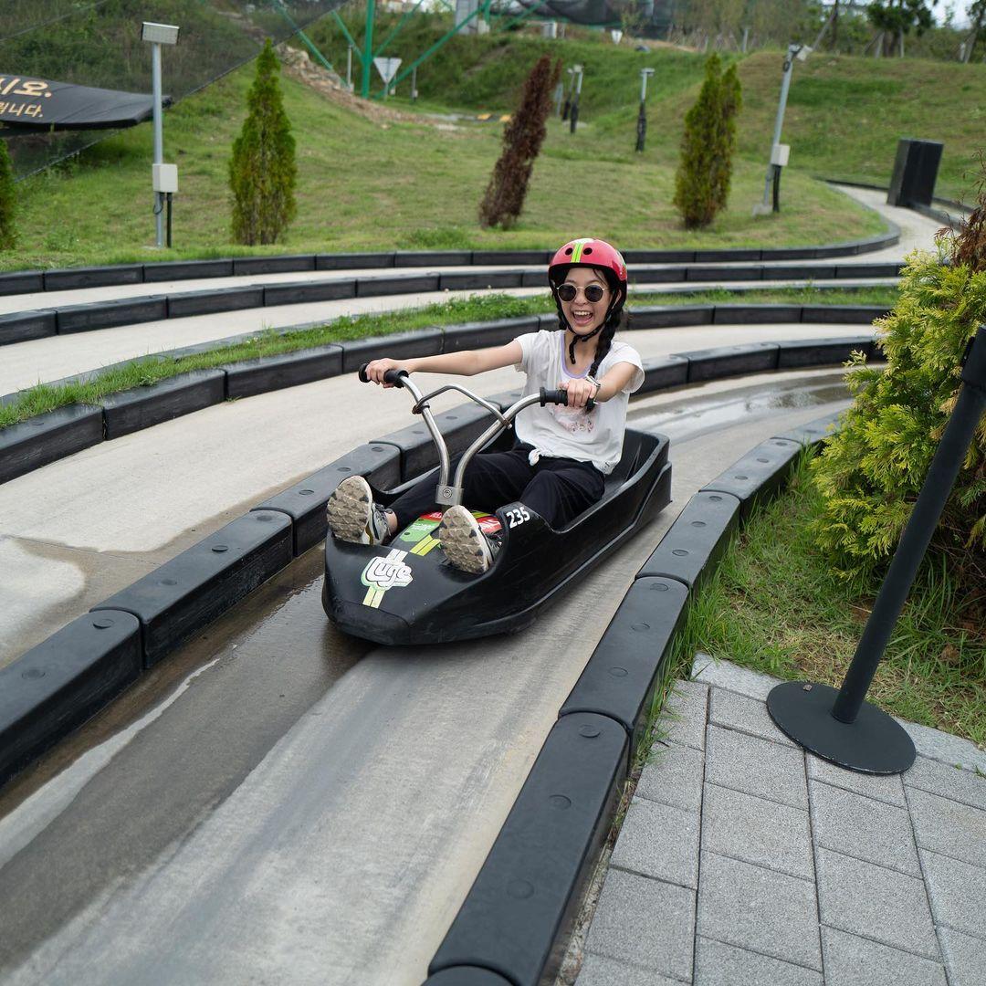 A girl smiles from ear to ear after completing a Luge ride at Busan.