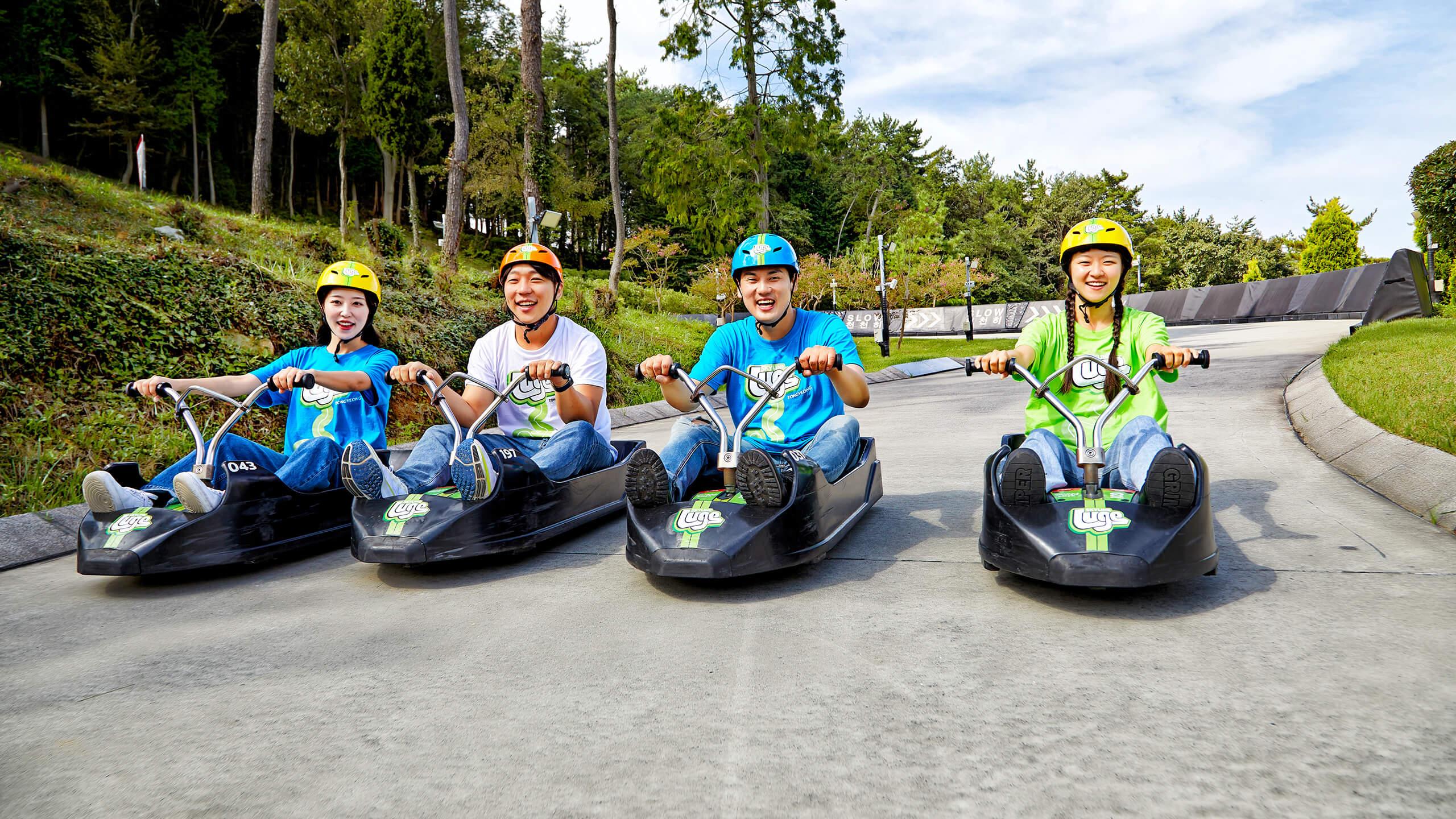 Four friends line up next to each other on the Luge tracks.