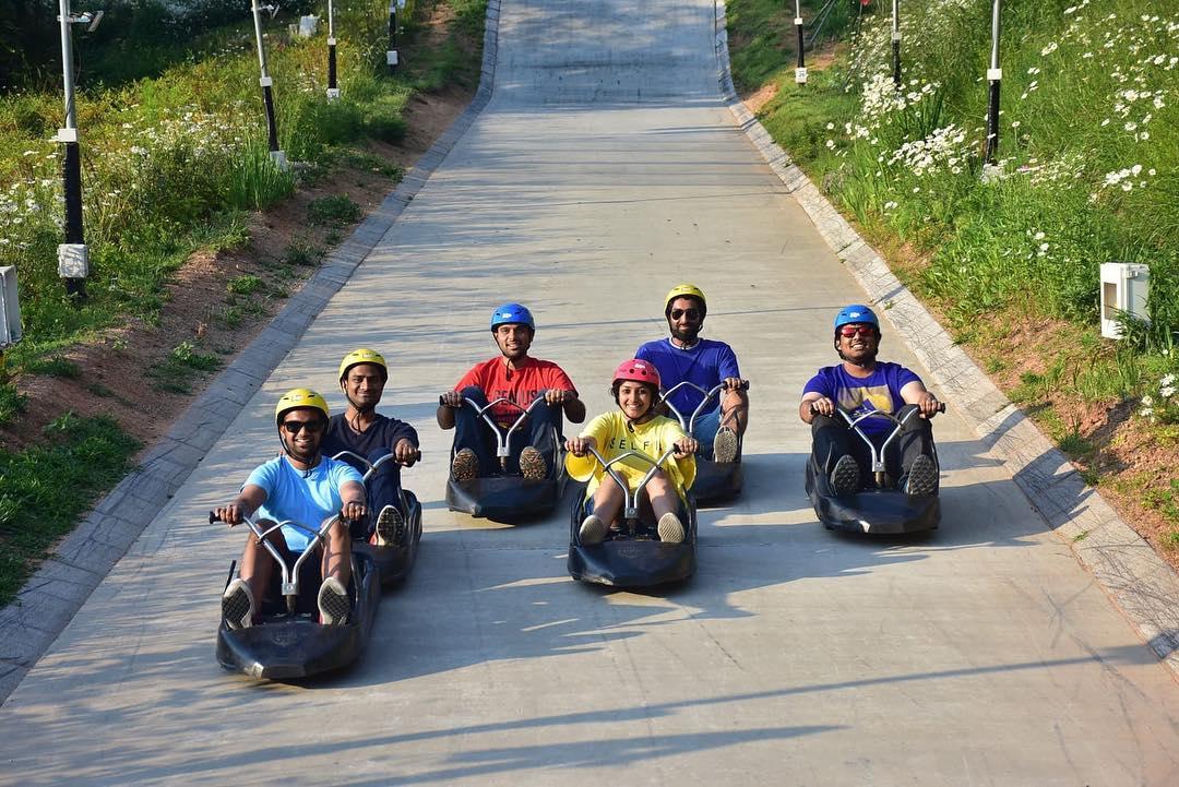 A large group of friends line up for a photo on the Luge tracks.