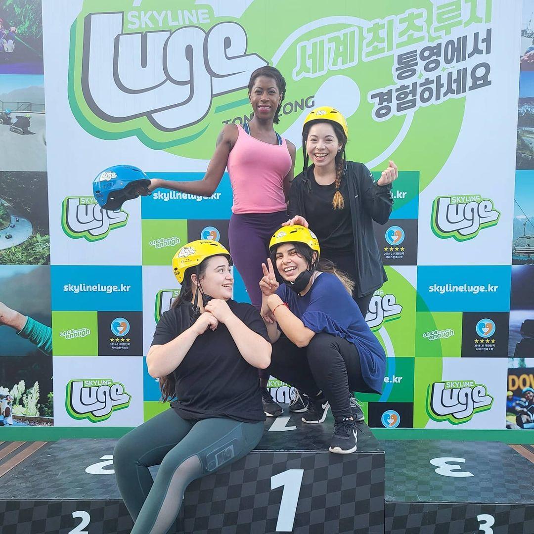A group of people pose for a photo on the podium at Skyline Luge Tongyeong.